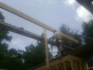 Carpenter setting a ridge beam over a new addition frame — Ice Dam Removal by Roofing Brothers in Mc Farland
