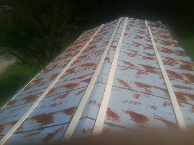 Rusted metal roof panels with new wood purlins before replacement — Storm Damage Roof Repair in Mc Farland by Roofing Brothers