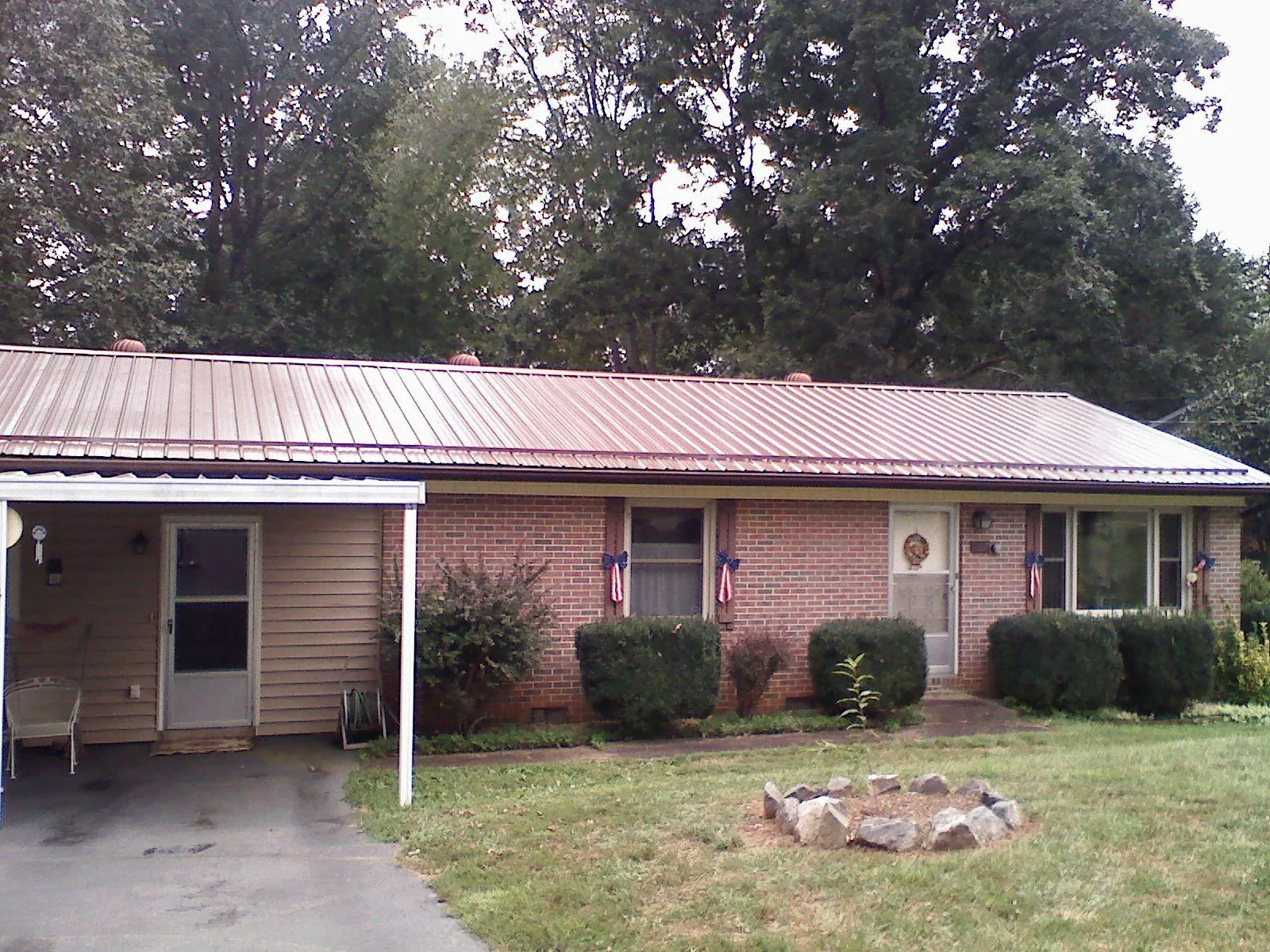 Bronze metal roof and carport on a brick ranch home — Roof Repair work by our crew in Mc Farland