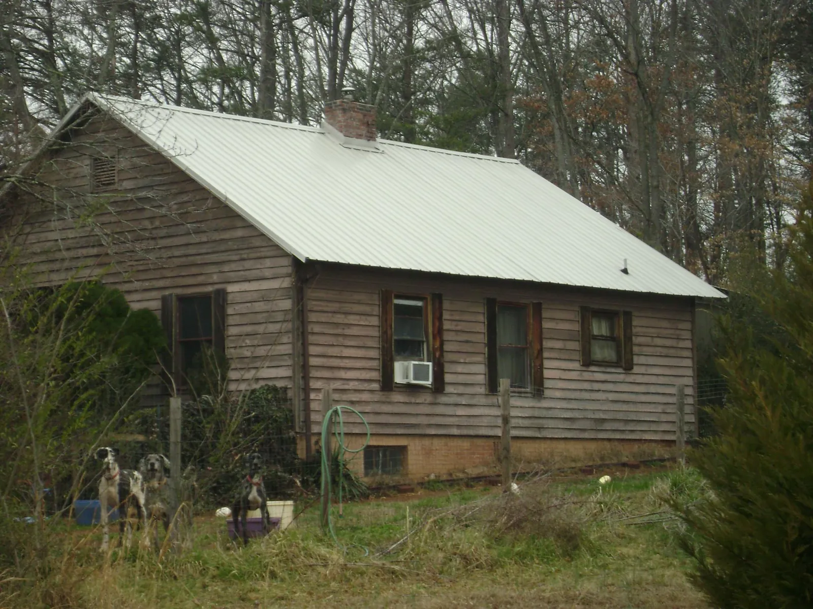 White metal roof on an old wood sided farmhouse, from a Metal Roof Installation job in Mc Farland